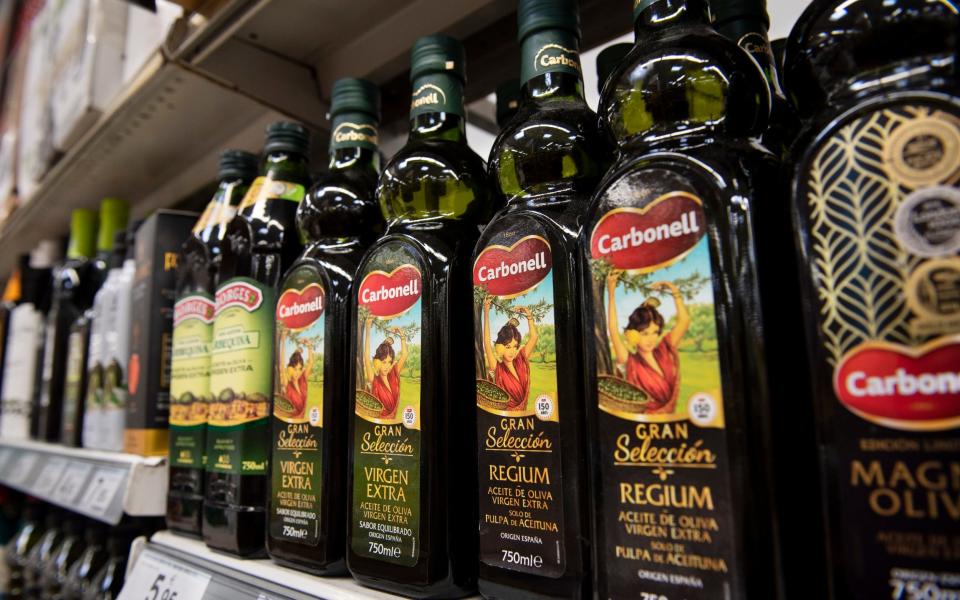 Bottles of Spanish olive oil are displayed for sale at a Carrefour supermarket in Spain, 2018