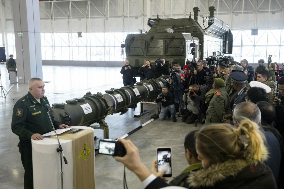 Lt. Gen. Mikhail Matveevsky, the chief of the military's missile and artillery forces, left, speaks during a briefing by the Russian Defense Ministry, as the 9M729 land-based cruise missile, center, is displayed near its launcher, right, in Kubinka outside Moscow, Russia, Wednesday, Jan. 23, 2019. The Russian military on Wednesday rolled out its new missile and spelled out its specifications, seeking to dispel the U.S. claim that the weapon violates a key nuclear arms pact. (AP Photo/Pavel Golovkin)