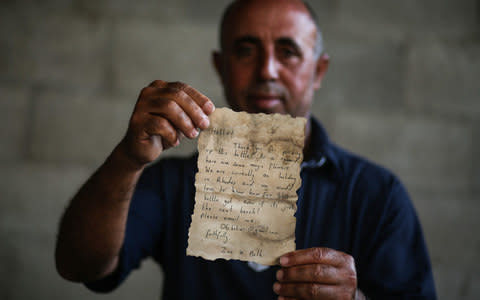 Jihad al-Soltan displays a letter after he found it in a bottle - Credit: Ali Jadallah/Anadolu Agency/Getty