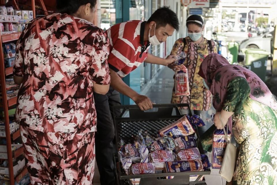 A Gardenia staff unloads fresh loaves of bread at a convenience store in Petaling Jaya March 25, 2020. — Picture by Ahmad Zamzahuri