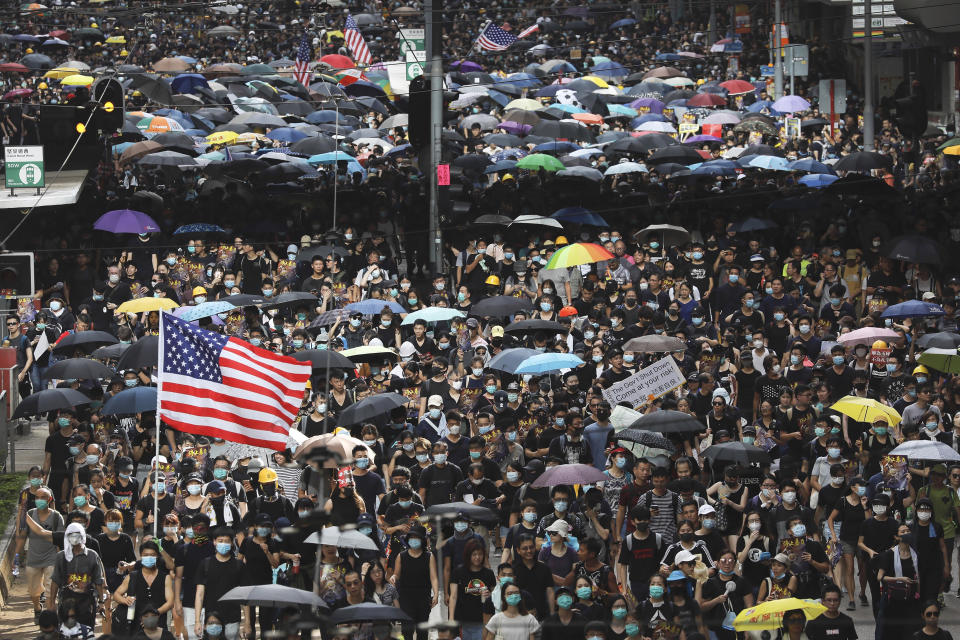 Protesters carry U.S. flags and placards during a protest march in Hong Kong, Sunday, July 28, 2019. A sea of black-shirted protesters, some with bright yellow helmets and masks but many with just backpacks, marched down a major street in central Hong Kong on Sunday in the latest rally in what has become a summer of protest. (AP Photo/Vincent Yu)