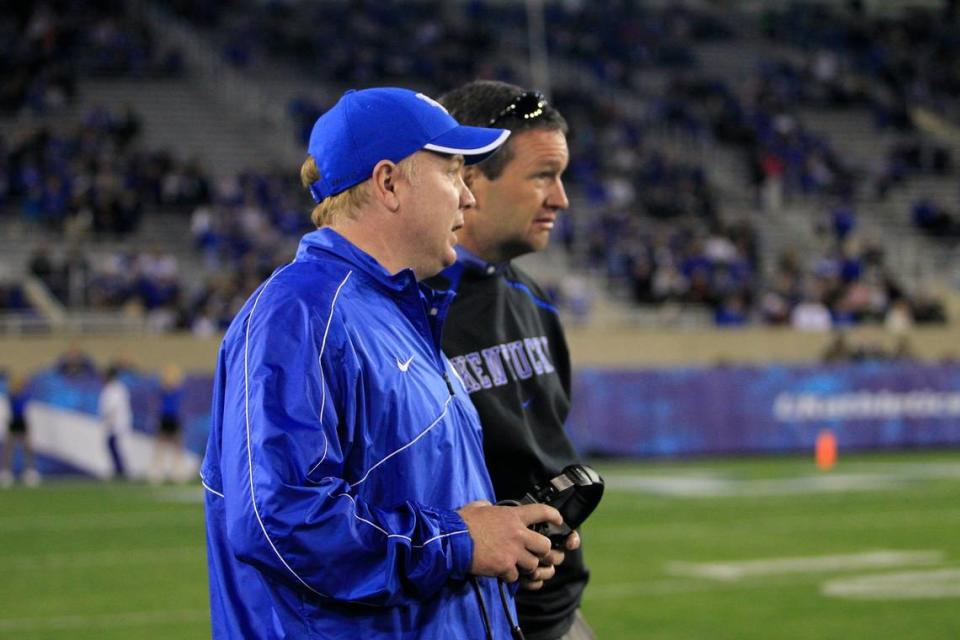 Kentucky coach Mark Stoops, left, and UK athletics director Mitch Barnhart, have been opposed to the Southeastern Conference going from eight to nine league football contests each year. Would the fortunes of the Wildcats football program have been better served if Stoops and Barnhart had instead fought to preserve the East and West divisions, which will go away after this season?