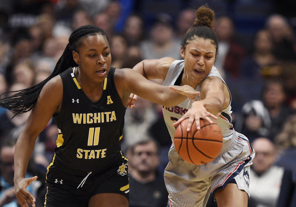 Wichita State's Ashlei Kirven, left, and Connecticut's Olivia Nelson-Ododa, right, reach for a loose ball during the first half of an NCAA college basketball game Thursday, Jan. 2, 2020, in Uncasville, Conn. (AP Photo/Jessica Hill)