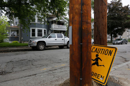A fallen caution sign sits across from a house, which according to law enforcement officials is one of the locations raided earlier in the day to break up heroin and fentanyl drug rings in the region, in Lawrence, Massachusetts, U.S., May 30, 2017. REUTERS/Brian Snyder