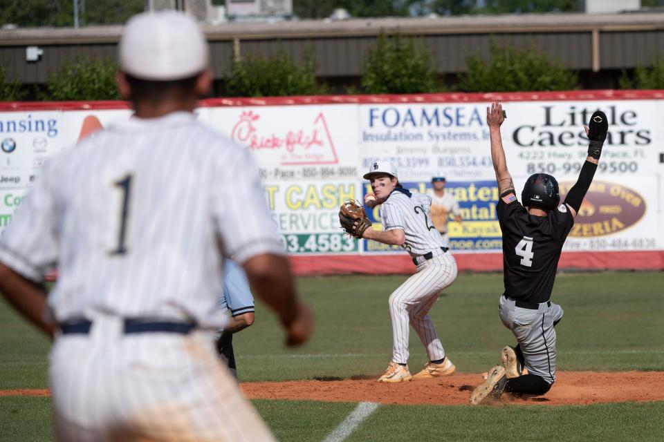 Tate's Jay Davis (No. 4) tries to break out a double play as Gulf Breeze's Carter McIlwain (No. 23) makes the throw to first during the District 1-6A tournament on Tuesday, May 2, 2023.