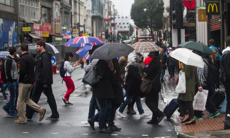 Shoppers sheltering from the rain in London’s Tottenham Court Road