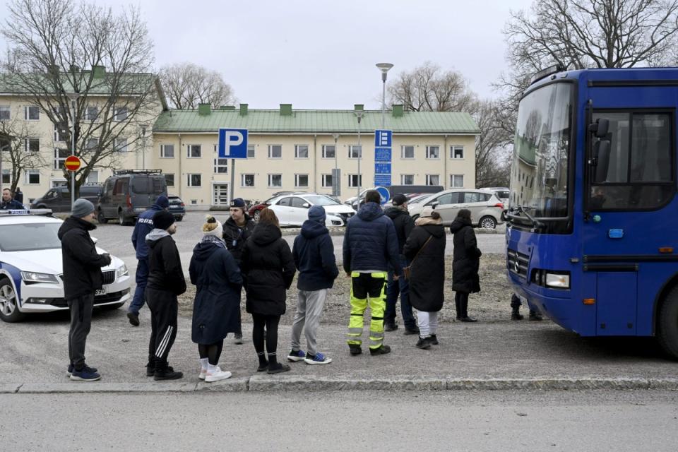 Police officers talk to family members of pupils at the school (Reuters)