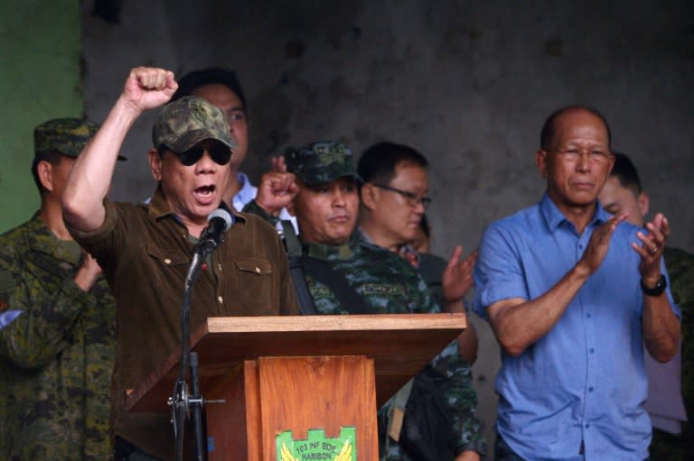 Philippines President Rodrigo Duterte (L) built his electoral success on crowd-pleasing pledges to rid the country of drugs and crime by killing tens of thousands of people