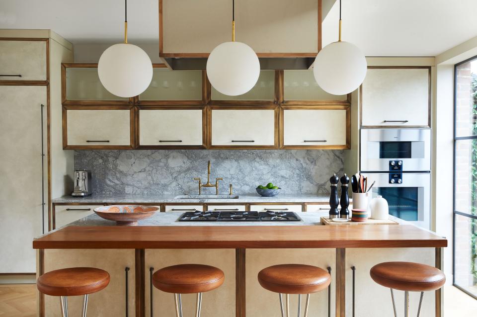 Brass details on the antique pendants and bespoke cabinetry warm up the kitchen. Gaggenau wall ovens and cooktop.