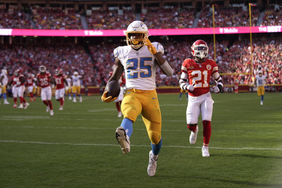 Los Angeles Chargers running back Joshua Kelley (25) scores past Kansas City Chiefs safety Mike Edwards (21) during the first half of an NFL football game Sunday, Oct. 22, 2023, in Kansas City, Mo. (AP Photo/Charlie Riedel)