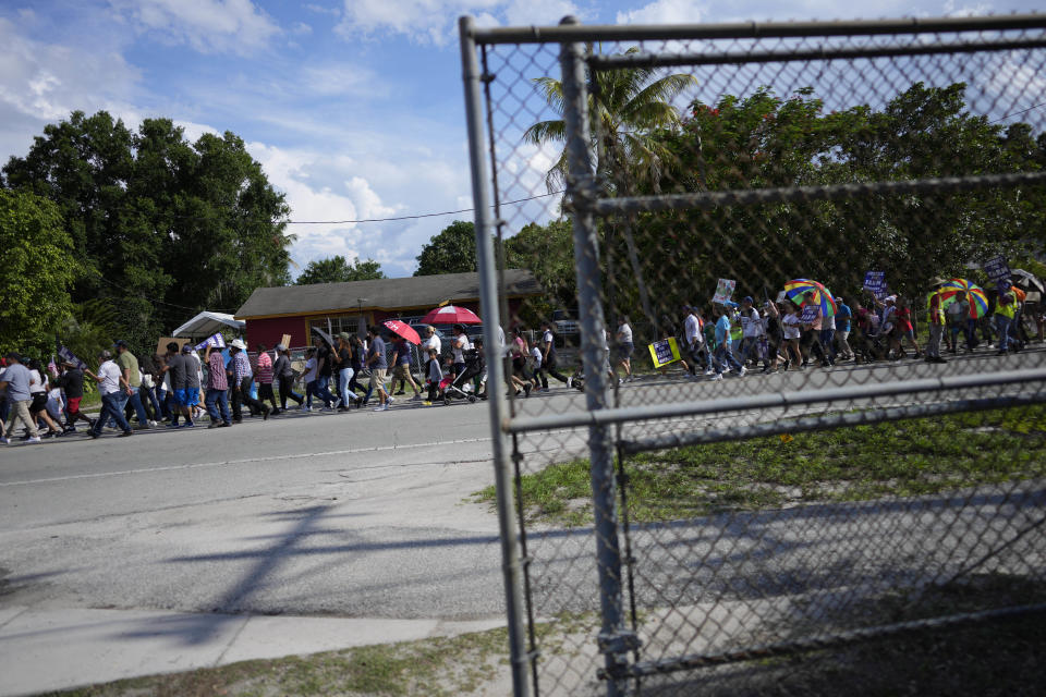 Hundreds march to protest peacefully against Florida Senate bill 1718, which imposes restrictions on undocumented immigrants, Thursday, June 1, 2023, in Immokalee, Fla., an area known for its tomato-growing. Across Florida Thursday, workers didn't show up at construction sites, and tomato fields, while scores of restaurants and small businesses never opened their doors to protest the new state law. (AP Photo/Rebecca Blackwell)