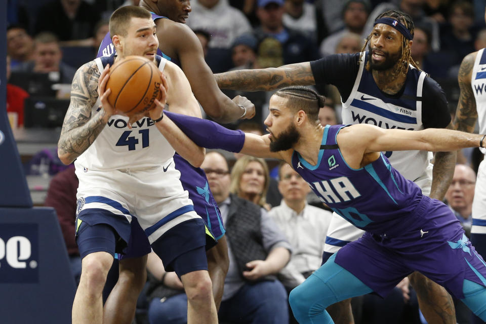 Charlotte Hornets' Caleb Martin, right, tries to knock the ball away from Minnesota Timberwolves' Juancho Hernangomez during the first half of an NBA basketball game Wednesday, Feb. 12, 2020, in Minneapolis. (AP Photo/Jim Mone)