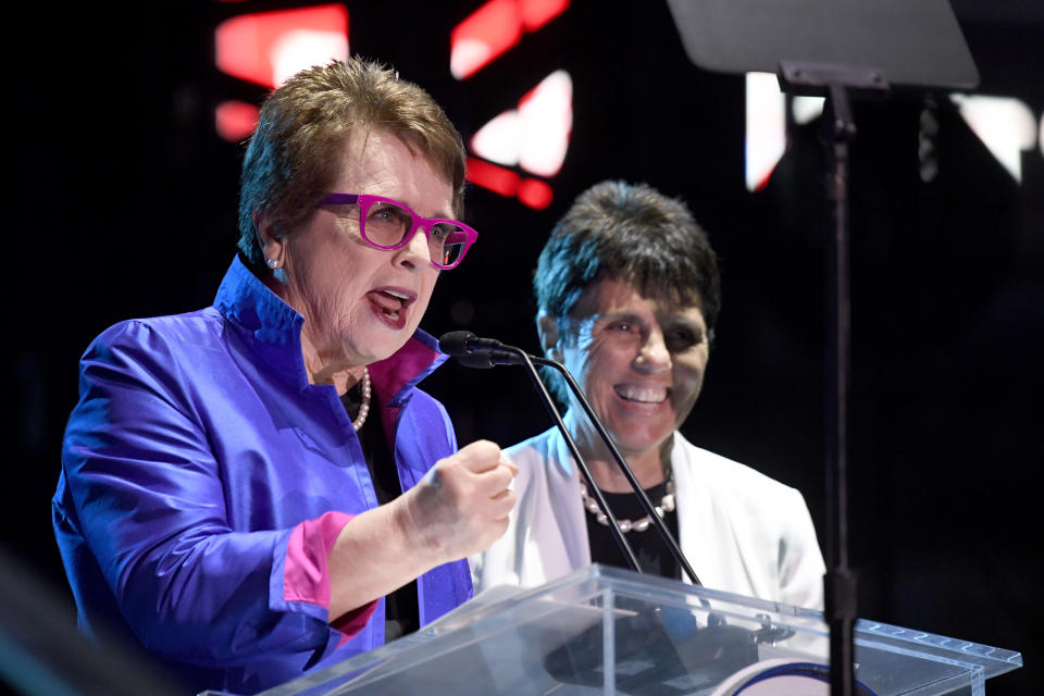 Billie Jean King speaks into a microphone at a podium next to Ilana Kloss.