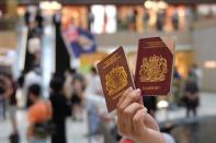 FILE PHOTO: A pro-democracy demonstrator raises his British National Overseas (BNO) passports during a protest against new national security legislation in Hong Kong