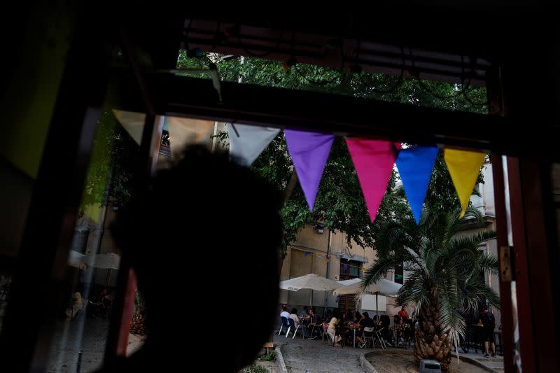 Carlos Gonzalez, from Venezuela, checks on the customers at the terrace of Taberna Angosta bar in central Madrid