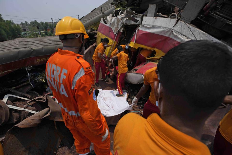 Rescuers carry the body of a victim of a passenger train that derailed in Balasore district, in the eastern Indian state of Orissa, Saturday, June 3, 2023. Rescuers are wading through piles of debris and wreckage to pull out bodies and free people after two passenger trains derailed in India, killing more than 280 people and injuring hundreds as rail cars were flipped over and mangled in one of the country’s deadliest train crashes in decades. (AP Photo/Rafiq Maqbool)