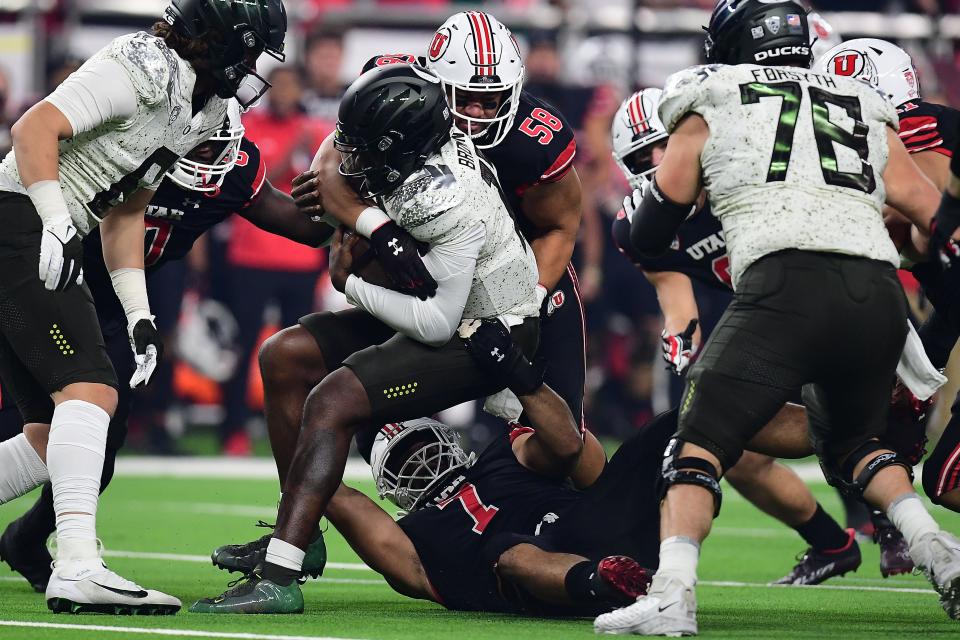 Oregon Ducks quarterback Anthony Brown (13) is brought down by Utah Utes defensive tackle Junior Tafuna (58) during the first half of Friday's Pac-12 championship game in Las Vegas.