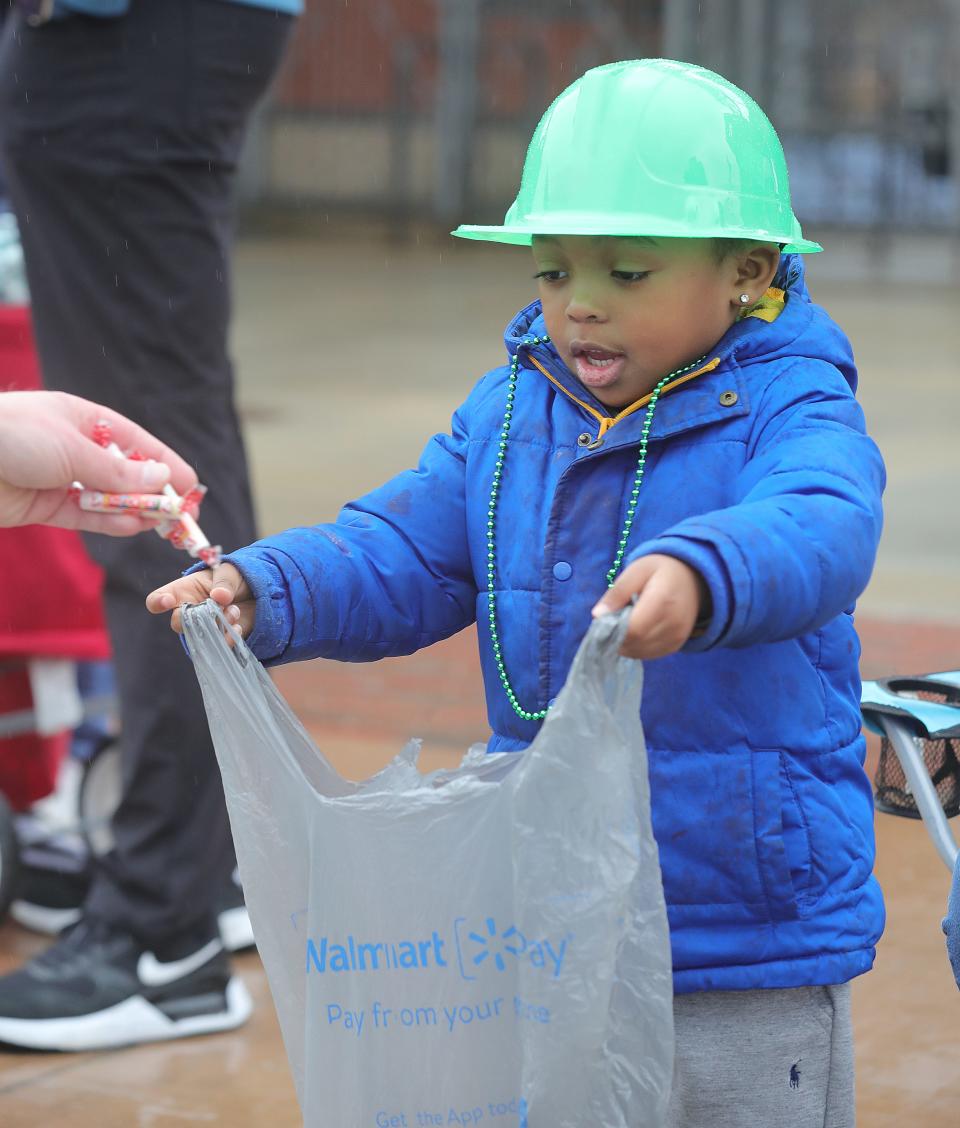 Dhay Simpson, 4, gets candy during the St. Patrick's Day Parade in downtown Akron Saturday.