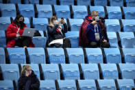 Team personnel wearing face masks to protect against COVID-19 watch the action at the ISU World Cup Short Track speed skating competition, a test event for the 2022 Winter Olympics, at the Capital Indoor Stadium in Beijing, Friday, Oct. 22, 2021. (AP Photo/Mark Schiefelbein)