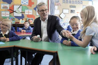 Labour Party leader Keir Starmer passes a toothbrush to a child during his visits to the Whale Hill Primary School as the Labour Party announces plans to tackle the crisis in children's dentistry and clear the backlog with 100,000 extra appointments for kids, whilst on the General Election campaign trail, in Eston, Middlesbrough, England, Tuesday, June 11, 2024. (Stefan Rousseau/PA via AP)