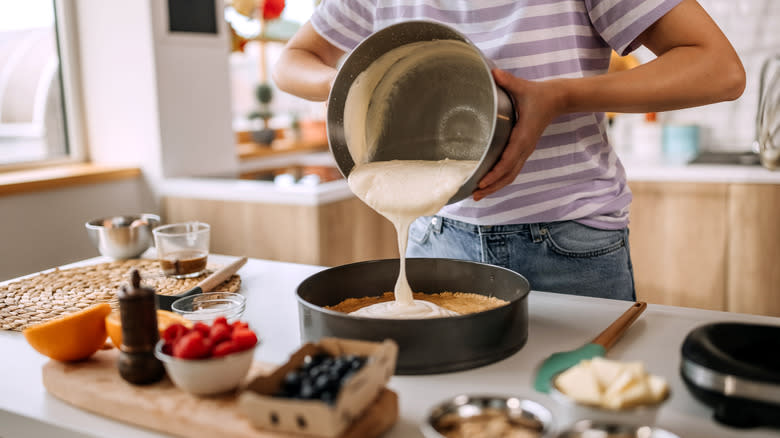 Person pouring batter into cake pan