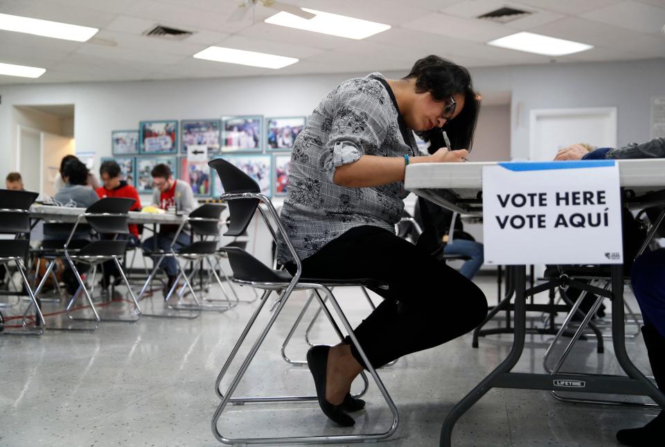 FILE - In this Feb. 15, 2020, file photo, a woman votes at an early voting location at the culinary workers union hall  in Las Vegas. Nevada Democrats are hoping to avoid a repeat of the chaos that ensnared the Iowa caucuses, as voters gather across the Silver State on Saturday to make their presidential preferences known.  (AP Photo/John Locher, File)