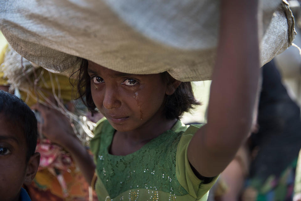 <p>OCT. 16, 2017 – A Rohingya girl cries as refugees fleeing from Myanmar cross a stream in the hot sun on a muddy rice field near Palang Khali, Cox’s Bazar, Bangladesh. Well over a half a million Rohingya refugees have fled into Bangladesh since late August during the outbreak of violence in Rakhine state causing a humanitarian crisis in the region with continued challenges for aid agencies. (Photo: Paula Bronstein/Getty Images) </p>