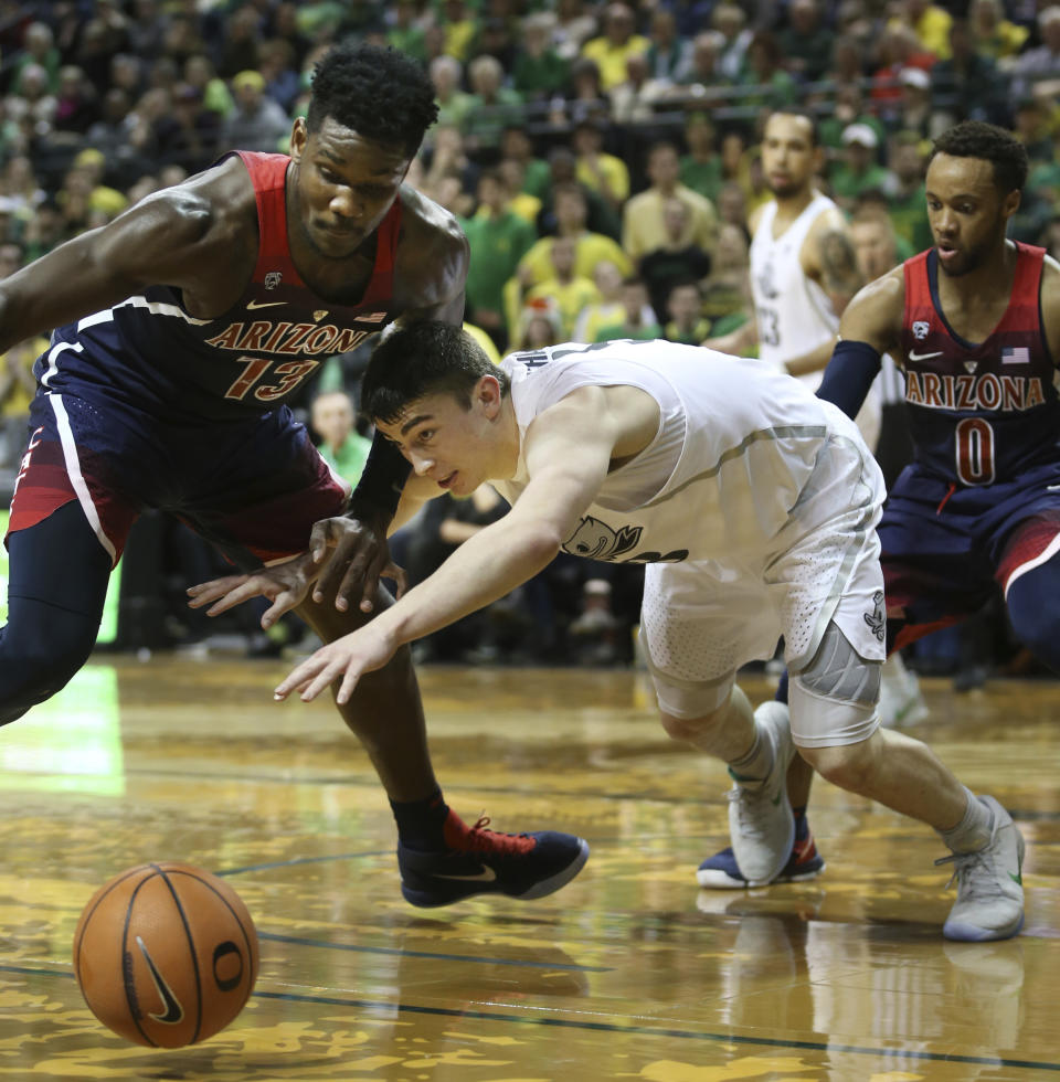 Arizona’s DeAndre Ayton, left, and Oregon’s Payton Pritchard, with Arizona’s Parker Jackson-Cartwright, right, battle for the ball during the first half of an NCAA college basketball game Saturday, Feb. 24, 2018, in Eugene, Ore. (AP photo/Chris Pietsch)