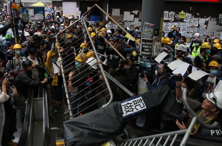 Pro-democracy protesters lift barricade reinforcements up onto an escalator near the government headquarters in the Admiralty district of Hong Kong on December 1, 2014