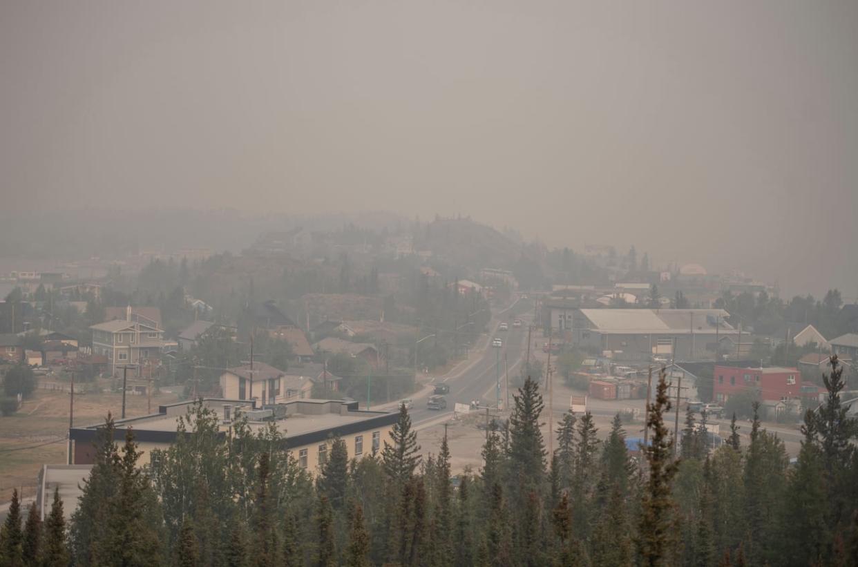 Heavy smoke from nearby wildfires fills the sky in Yellowknife last August. The territory's chief public health officer has said health impacts from last summer's wildfires will take years to understand.  (Angela Gzowski/The Canadian Press - image credit)