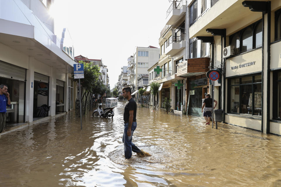 A man crosses a flooded street after a storm at Karditsa town, Saturday, Sept. 19, 2020. Two people have died and one is reported missing in the central Greek region of Thessaly as a rainstorm pounded parts of central and western Greece overninght and caused rivers to burst their banks and flood surrounding areas. (AP Photo/Vaggelis Kousioras)