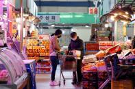 A woman wearing a mask to prevent contracting the coronavirus shops at a traditional market in Seoul