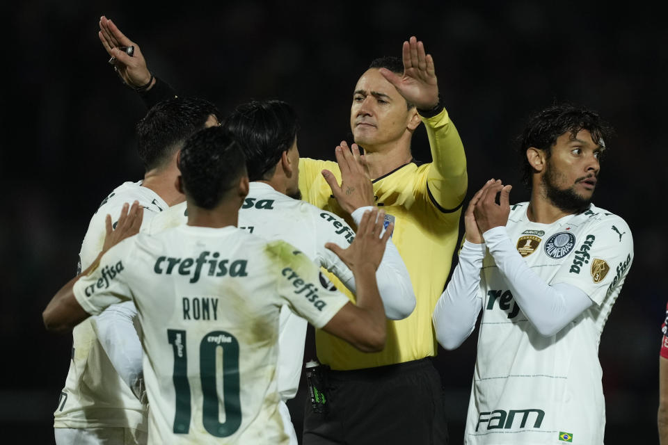 Players of Brazil's Palmeiras complain to referee Wilmar Roldan, of Colombia, during a Copa Libertadores round of sixteen first leg soccer match against Paraguay's Cerro Porteno in Asuncion, Paraguay, Wednesday, June 29, 2022. (AP Photo/Jorge Saenz)