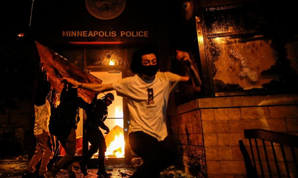 Protesters react set fire to the entrance of a police station in Minneapolis, Minnesota.