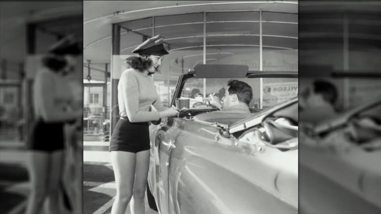 carhop delivering burger order in the '50s 