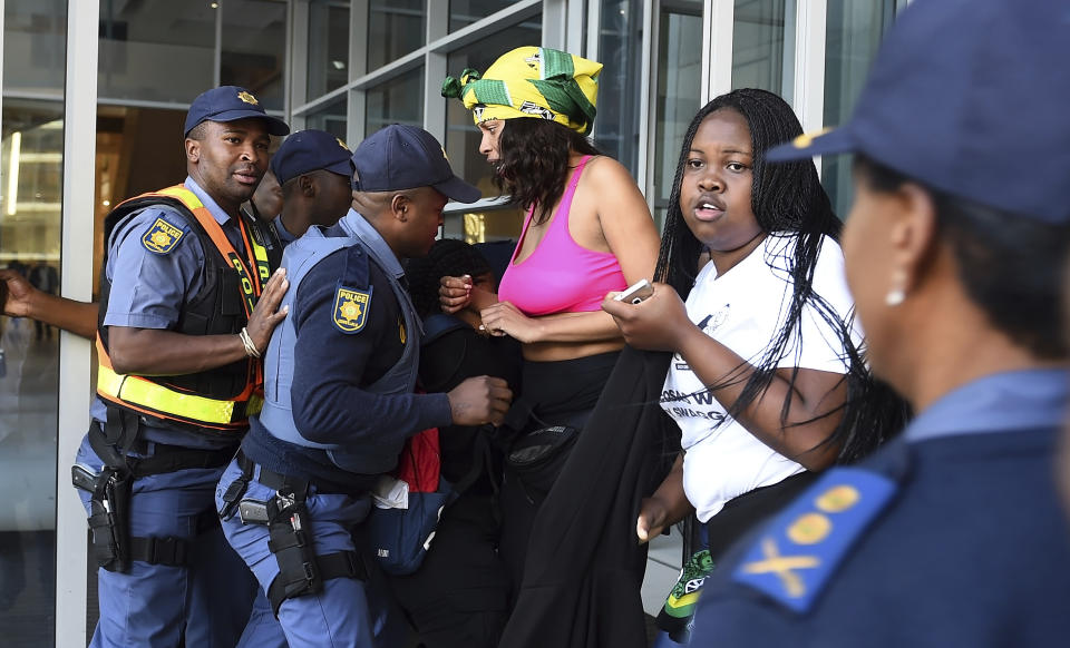 Protesters break through a police cordon to gain entry where the World Economic Forum on Africa is being held in Cape Town, South Africa, Wednesday, Sept. 4, 2019. The women are demanding that the government crack down on gender-based violence, following a week of brutal murders of young South African women that has shaken the nation. (AP Photo)