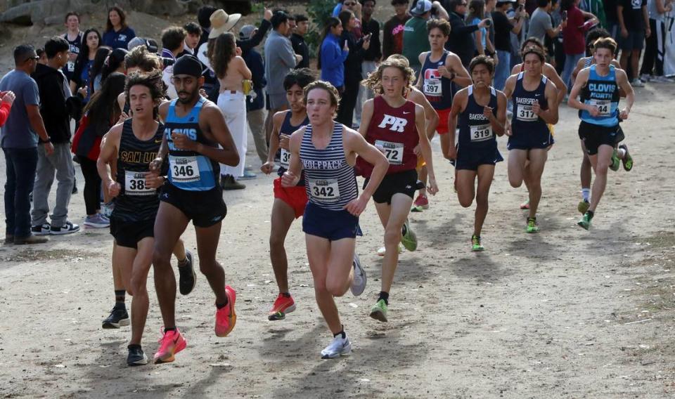 Clovis North senior Teg Pandher (2nd, 15:25.65) and Clovis East senior (1st, 15:20.45) lead the Division I runners past the 1-mile mark at the CIF Central Section cross country championships at Woodward Park on Nov. 16, 2023.