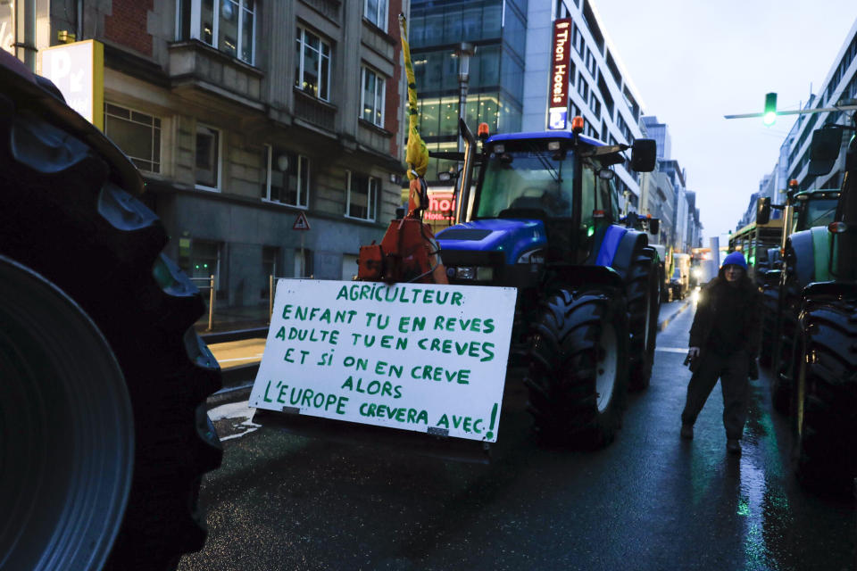 Tractors arrive in the European Quarter during a protest of farmers outside a meeting of EU agriculture ministers in Brussels, Monday, Feb. 26, 2024. European Union agriculture ministers meet in Brussels Monday to discuss rapid and structural responses to the crisis situation facing the agricultural sector. Sign reads, 'Farmer, as a child you dream of it as an adult you die of it, then Europe will die with it'. (AP Photo/Nicolas Landemard)