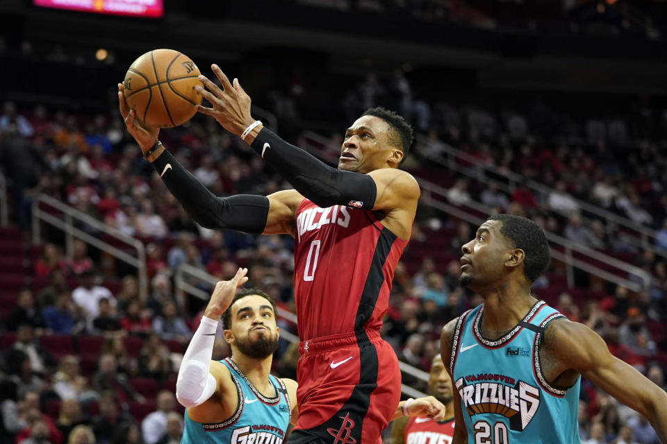 Houston Rockets' Russell Westbrook (0) goes up for a shot as Memphis Grizzlies' Josh Jackson (20) and Tyus Jones, left, defend during the first half of an NBA basketball game Wednesday, Feb. 26, 2020, in Houston. (AP Photo/David J. Phillip)