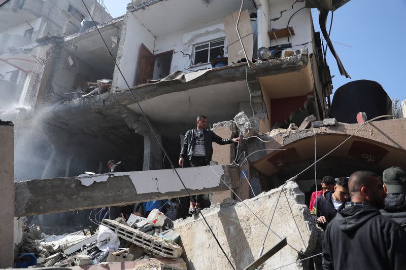 Palestinians inspect the site of an Israeli strike on a house, in Rafah