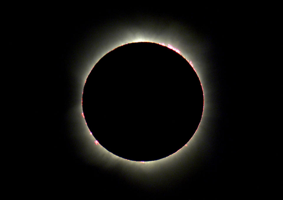 Solar eclipse showing the sun's corona and Baily's beads effect around the moon's silhouette