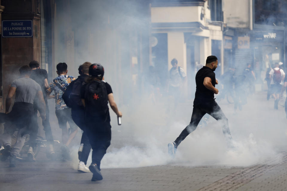 FILE - Youths run away during a protest Friday, June 30, 2023 in Strasbourg, eastern France. Small-town mayors where vehicles were torched, fires lit and police attacked are scratching their heads, trying to figure out why them, why now and whether France's urban blights that previously seemed far away are sinking roots into their peace and quiet, too. (AP Photo/Jean-Francois Badias, File)