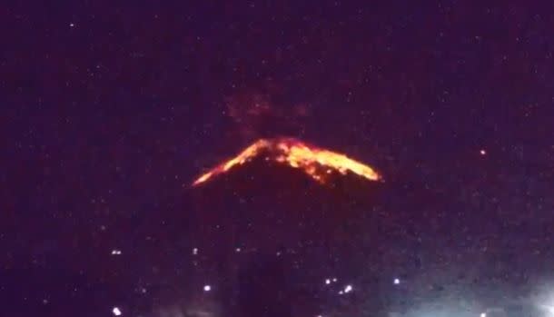 Mt Agung is pictured with lava flowing down the mountainside after an eruption on Friday night (local time).