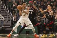May 17, 2019; Milwaukee, WI, USA; Milwaukee Bucks forward Giannis Antetokounmpo (34) passes the ball under pressure from Toronto Raptors forward Pascal Siakam (43) and guard Danny Green (14) during the first quarter in game two of the Eastern conference finals of the 2019 NBA Playoffs at Fiserv Forum. Mandatory Credit: Jeff Hanisch-USA TODAY Sports