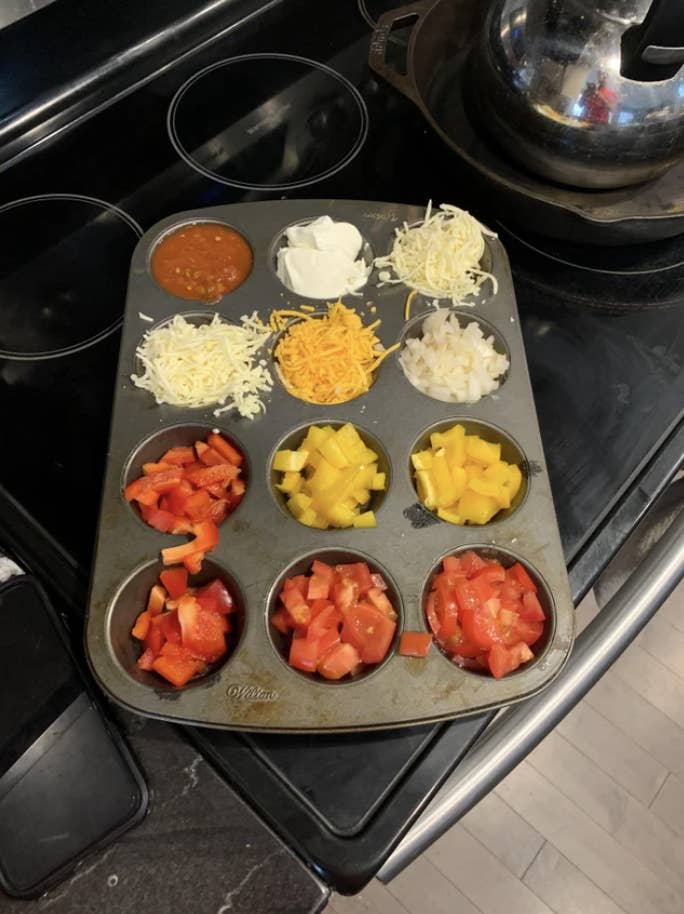 a muffin tin with different taco toppings in each nook