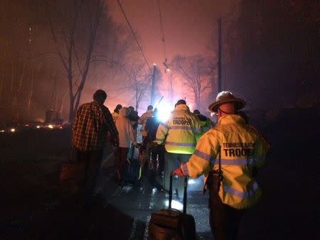 Troopers from the Tennessee Highway Patrol help residents leave an area under threat of wildfire after a mandatory evacuation was ordered in Gatlinburg, Tennessee in a picture released November 30, 2016. Tennessee Highway Patrol/Handout via REUTERS