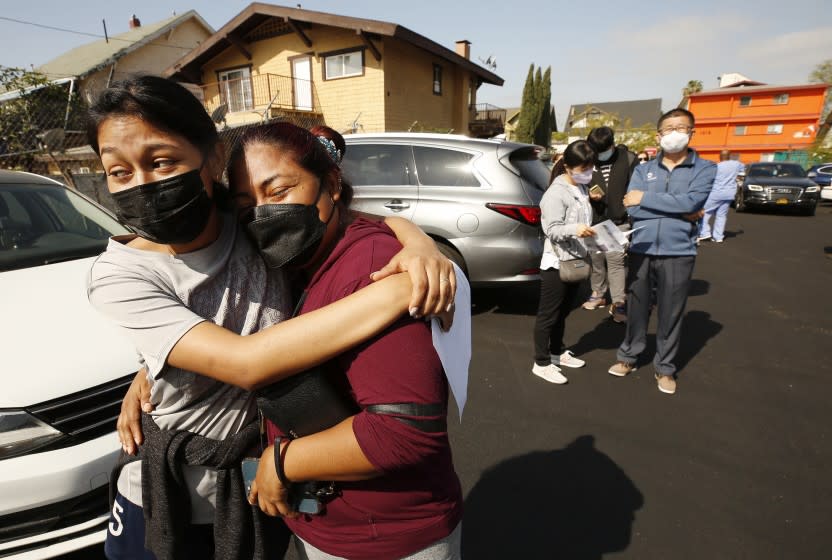 LOS ANGELES, CA - APRIL 20: Jeymy Mendoza, 16, hugs her mother Maria Jimenez, 34, as they wait in line to receive the Pfizer Covid-19 vaccination at a new, walk-up mobile COVID-19 clinic launched today to provide the Pfizer COVID-19 vaccine to underserved communities in Los Angeles. The walk-up clinic was presented by Councilmember Mark Ridley-Thomas in partnership with CHA Hollywood Presbyterian Medical Center (CHA HPMC) and the Southern California Eye Institute (SCEI). The Mobile Vaccine Clinic at 1819 S. Western Avenue will be open every Tuesday starting April 20 through May 25 providing free vaccines to community members who are eligible per LA County Department of Public Health (LAC DPH) vaccine distribution guidelines as they partnered with Charles R. Drew University of Medicine and Science to provide student volunteers for on-site registration allowing for walk-up appointments for community members and further ensuring vaccine access in our hardest-hit communities. Los Angeles on Tuesday, April 20, 2021 in Los Angeles, CA. (Al Seib / Los Angeles Times).