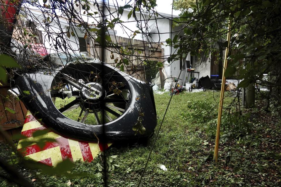 FILE -The tail rotor of a Broward Sheriff's Office Fire-Rescue helicopter is seen in the backyard of a home after crashing on Monday, Aug. 28, 2023, near Fort Lauderdale. Fla. A pilot told investigators he heard a loud bang before a Florida medical rescue helicopter caught fire in flight last month, leading to a crash that killed a paramedic and a woman on the ground, a federal report released Friday, Sept. 8, 2023 said. (Joe Cavaretta/South Florida Sun-Sentinel via AP, File)