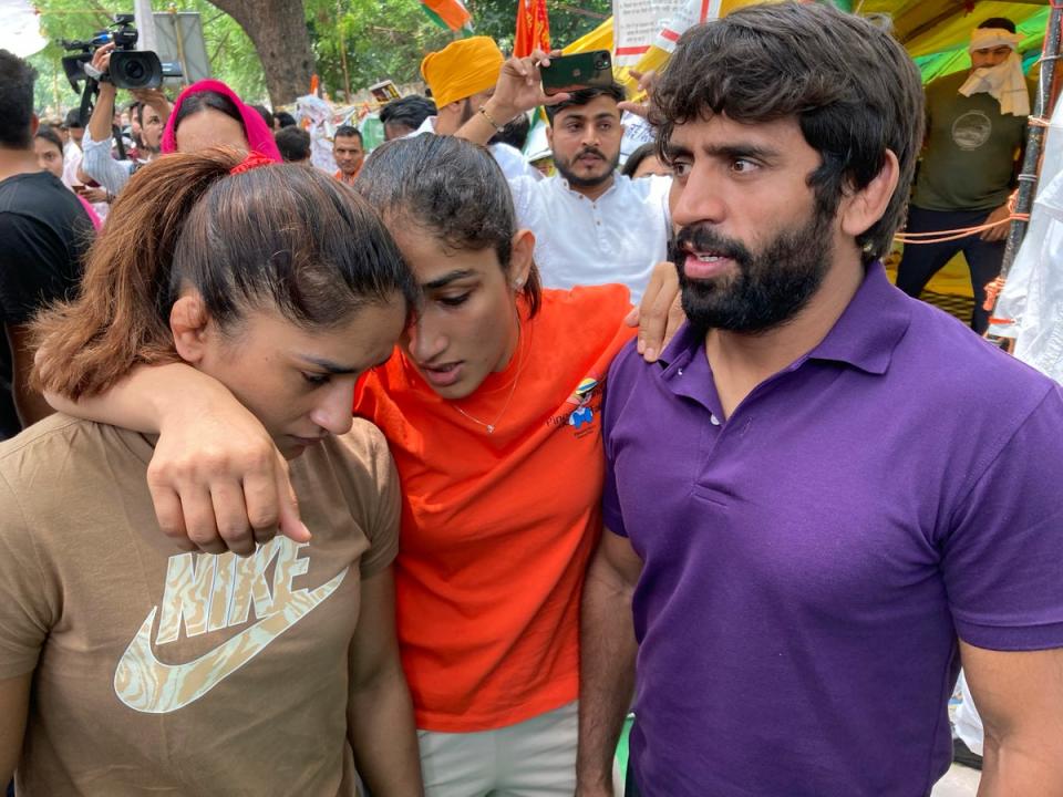 Indian wrestlers (from right) Bajrang Punia, Sangita Phogat and Vinesh Phogat talk to each other ahead of their protest march (AP)