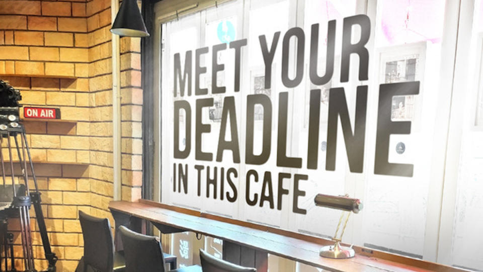 Text spells out "Meet Your Deadline in this cafe" in the window of the Manuscript Writing Cafe